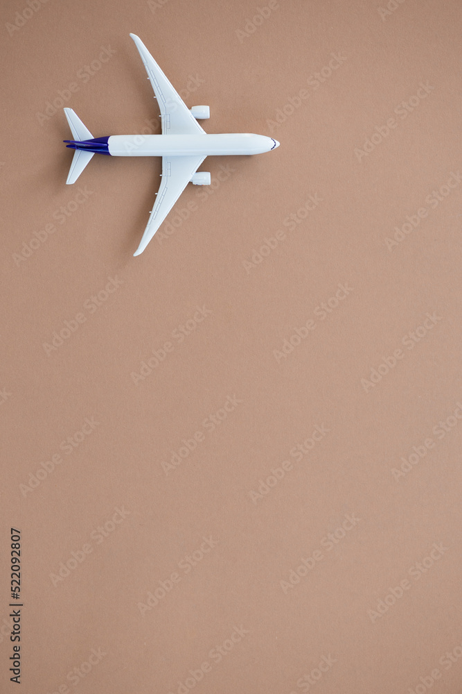 Miniature toy airplane on beige background. Summer holiday air travel by plane concept.