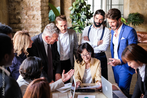 Group of businessmen gathered around the female boss responsible for the coworking space