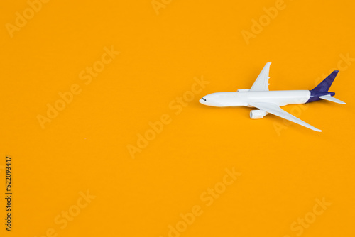 Travel concept on yellow background with copy space. Airplane toy on yellow color background.