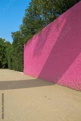 Vertical shot of a pink wall and sandy ground at Luis Barragan's equestrian estate in Mexico City photo