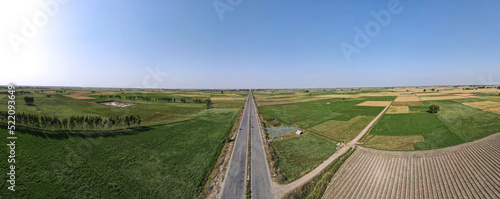 A 180 degree panorama of long road leading to District Narowal of Punjab province. It was captured with a drone amid wheat fields and honey bee farms photo