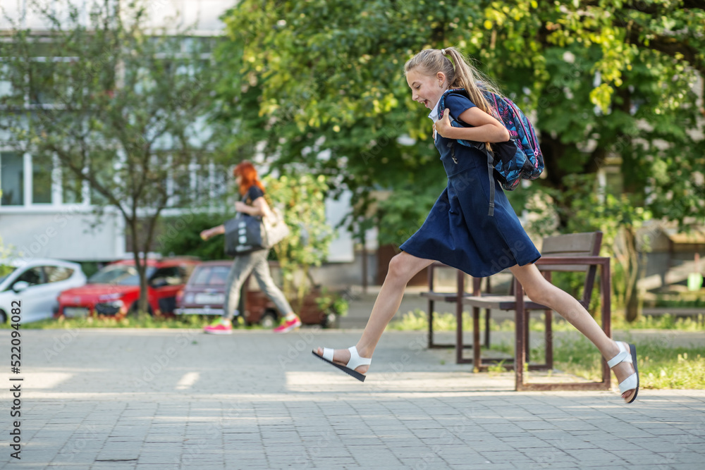 Pretty teenage girl runs with backpack to school. Back to school and education concept