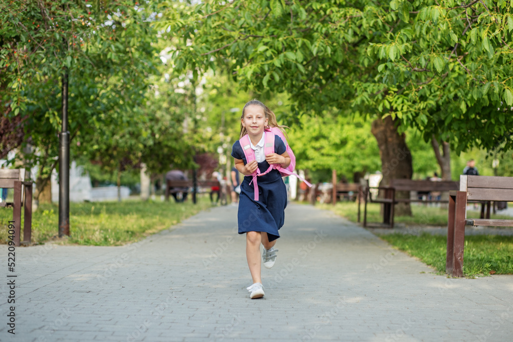 Beautiful schoolgirl runs with backpack to school. Concept back to school, education