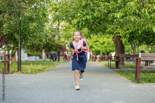 Beautiful schoolgirl runs with backpack to school. Concept back to school, education © Olha Tsiplyar