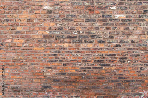 Full frame texture background of an antique European brown and red color brick wall in an Old English Bond brickwork pattern