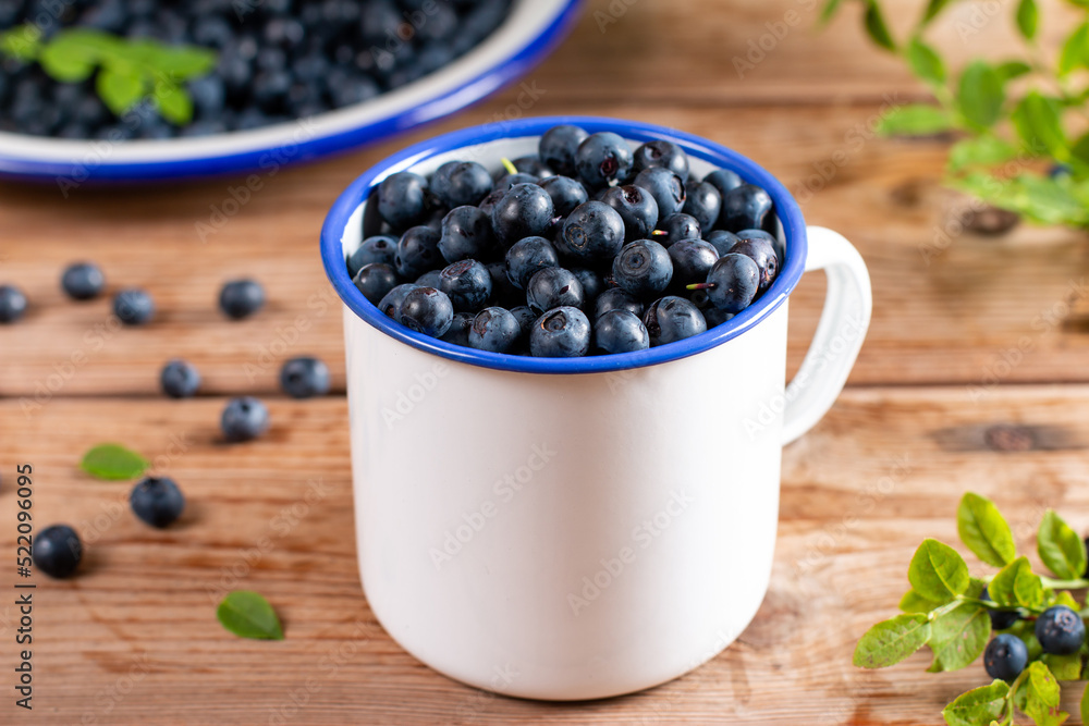 Fresh raw organic farm blueberry in white cup on wooden table Fresh raw organic farm blueberry in white cup on wooden table