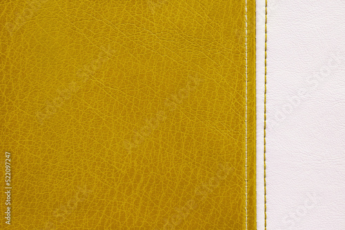 Natural, artificial yellow and white leather texture background with vertical decorative seam. Material for sport items, clothes, furnitre and interior design. ecological friendly leatherette. photo