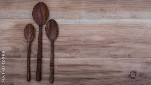 Three wooden spoons head on a wooden background. wooden utensils. wooden spoon