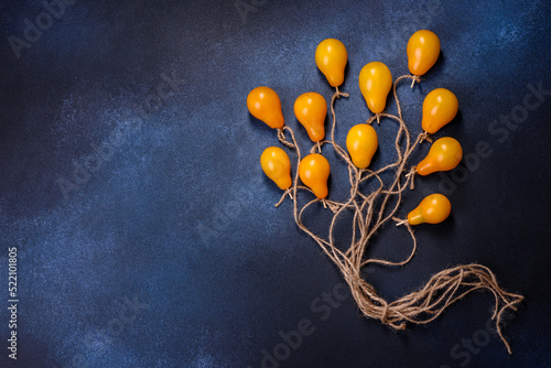 The concept idea in the form of balloons on ropes is made of yellow tomatoes