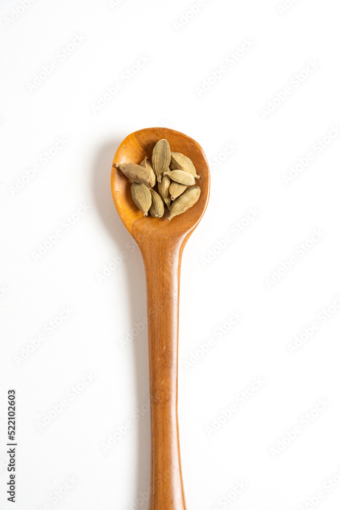 cardamom on a wooden spoon cardamom on a wooden spoon
