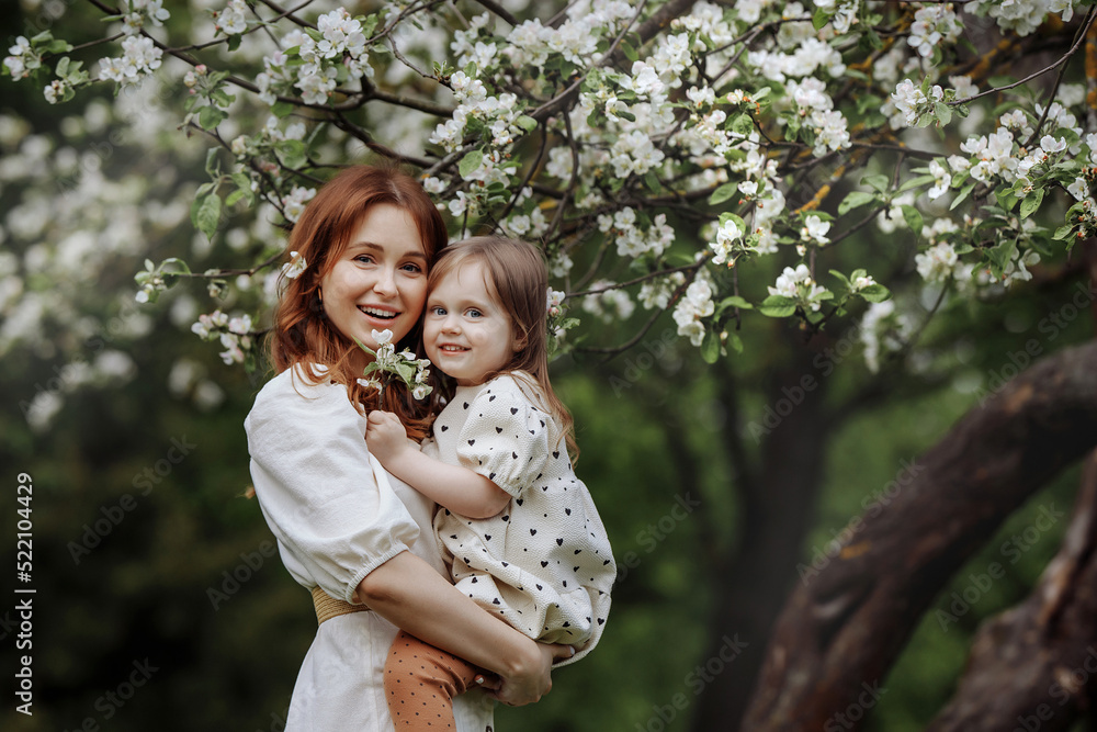 Mom and little daughter in the apple orchard Mom and little daughter in the apple orchard