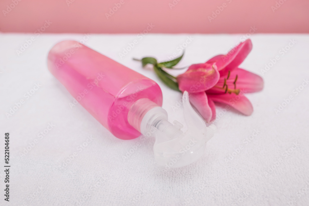 Spray bottle with pink liquid and rose flower. Spray bottle with pink liquid and rose flower.