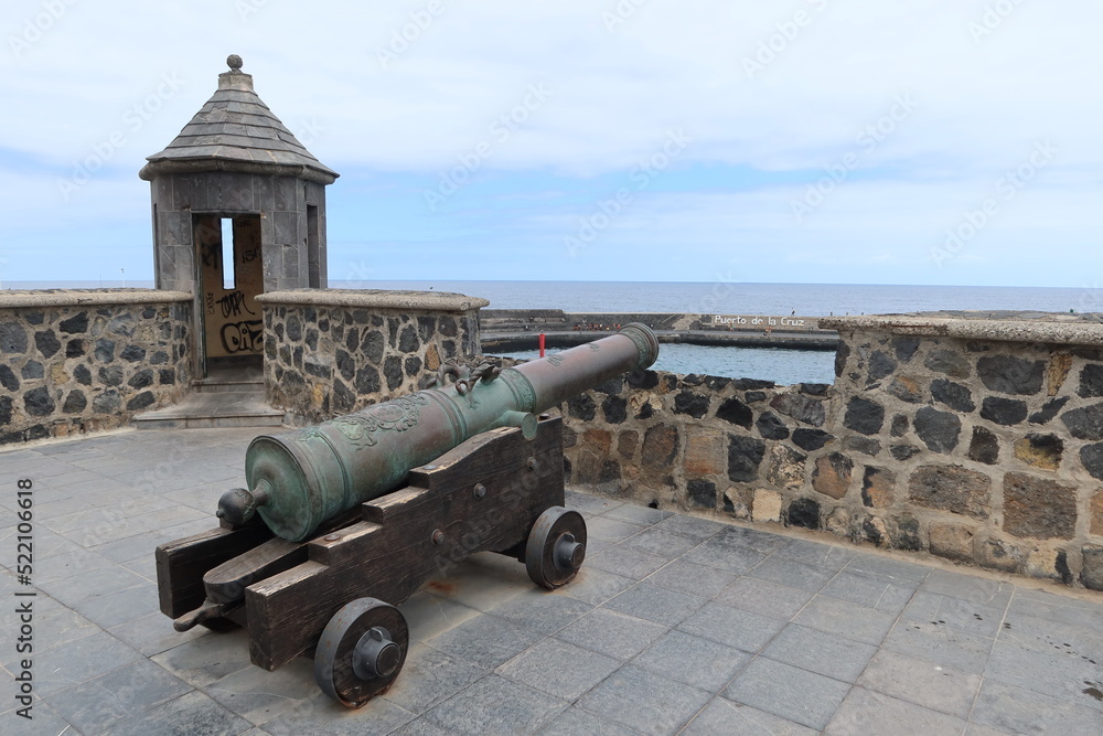 Puerto de la Cruz, Tenerife, Canary Islands, Spain, May 27, 2022: Old cannon and sentry box on the boardwalk at the entrance to the port in Puerto de la Cruz, Tenerife