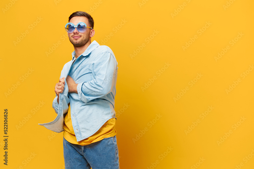 Overjoyed tanned handsome man in blue shirt trendy sunglasses dance sing posing isolated on orange yellow studio background. Copy space Banner Mockup. Relax time Party concept Overjoyed tanned handsome man in blue shirt trendy sunglasses dance sing posing isolated on orange yellow studio background. Copy space Banner Mockup. Relax time Party concept