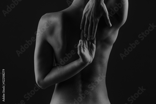 girl's back close-up on a dark background, the concept of treatment of the spine and back
