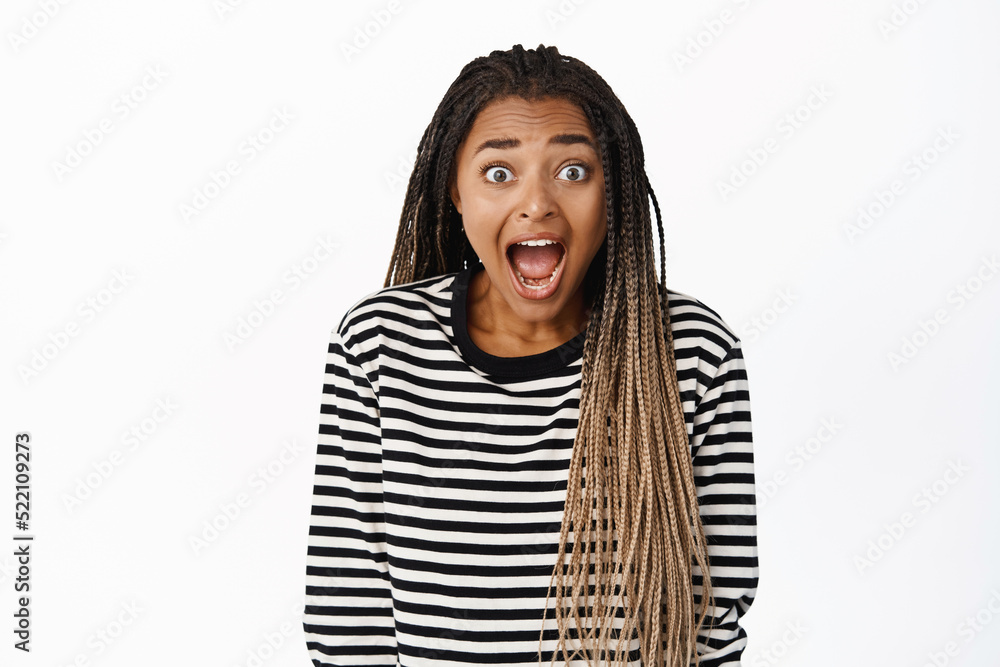 Image of excited black girl staring impressed at camera, checking out big promo sale, screaming of amazement and joy, look with awe and disbelief, white background Image of excited black girl staring impressed at camera, checking out big promo sale, screaming of amazement and joy, look with awe and disbelief, white background