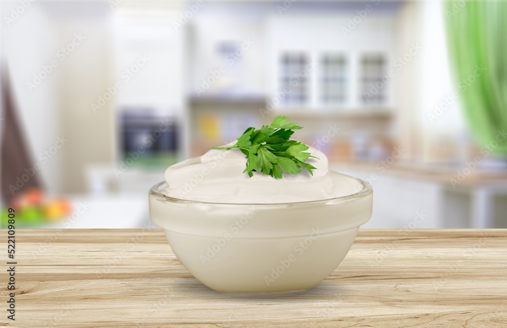 Bowl of tasty mayonnaise with parsley on the desk Bowl of tasty mayonnaise with parsley on the desk
