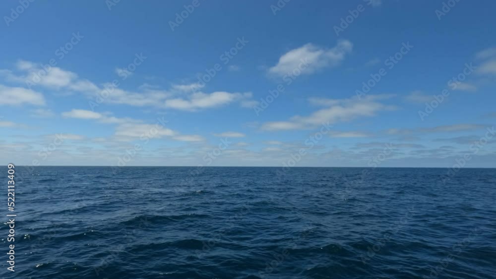Ocean with Waves and Blue Sky with Clouds a View from A Moving Ship Looking Far at Horizon Line
Ocean with Waves and Blue Sky with Clouds a View from A Moving Ship Looking Far at Horizon Line