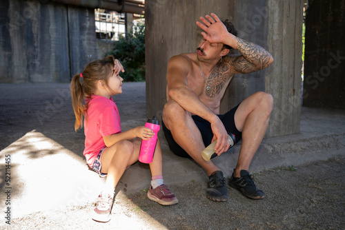 A father and his daughter are resting after a workout. photo