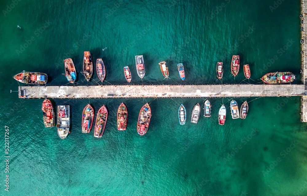 Fototapeta premium Aerial drone shot of many fishing boats in Kalk Bay harbour, near Cape Town, South Africa