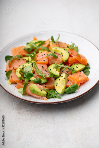 Salmon salad with avocado, for keto and low carb diet. Rusty background, top view, copy space.