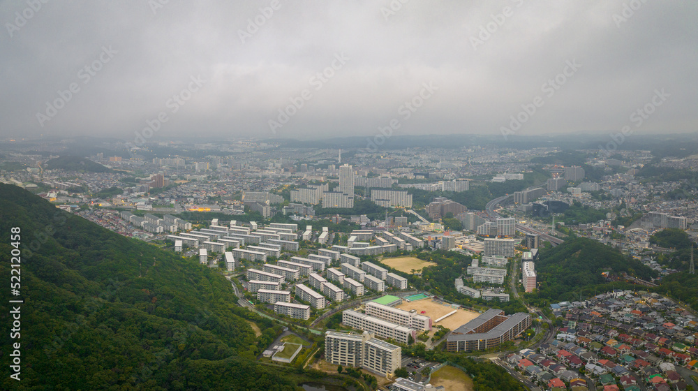 Apartment blocks in development at base of forested hill on edge of city