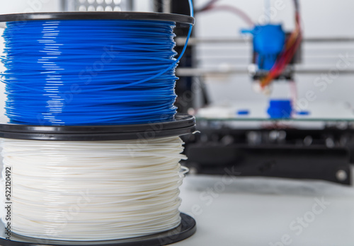 Personal 3d printer and abs or pla filament coils next to him. photo