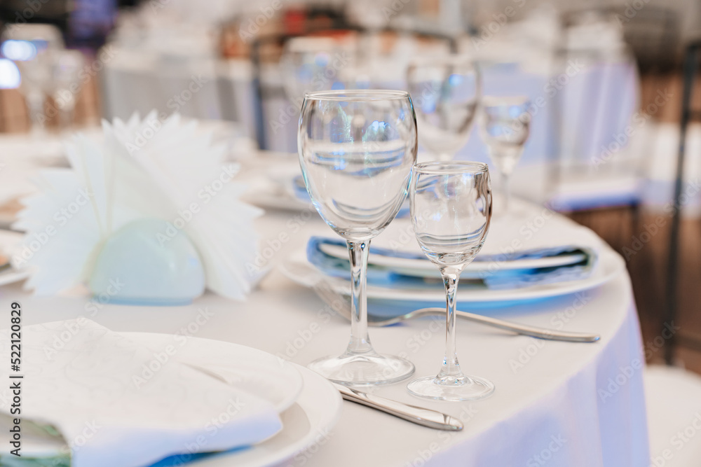 empty wine glasses on a round table with a white tablecloth. 