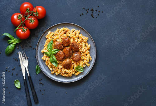 Italian pasta with meatballs, tomato sauce and spices, top view, with space for text