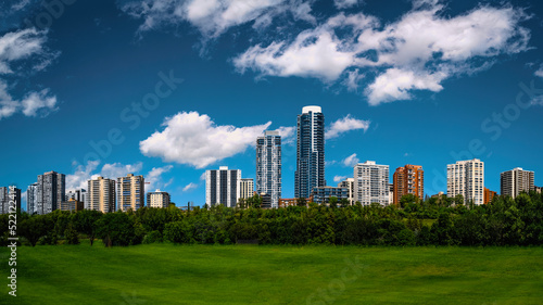 Edmonton skyline and cityscape with dramatic clouds over Victoria Park's green in the Province of Alberta, Canada © Naya Na