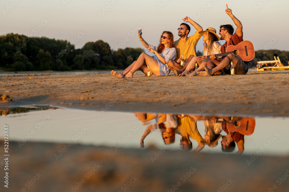 group of people on the beach taking selfies and enjoying free time