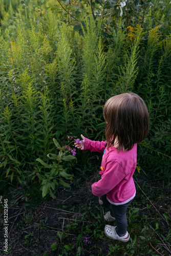 Wallpaper Mural A small girl in pink t-shirt looking at plants Torontodigital.ca