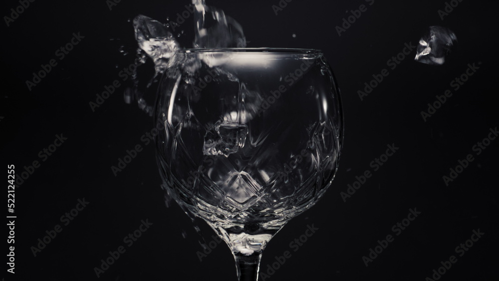 Ice cubes lemons falls empty wineglass closeup. Refreshing drink concept Ice cubes lemons falls empty wineglass closeup. Refreshing drink concept