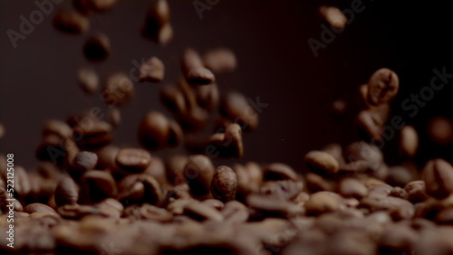 Closeup coffee beans fall on heap. Brown fresh seeds pouring super slow motion