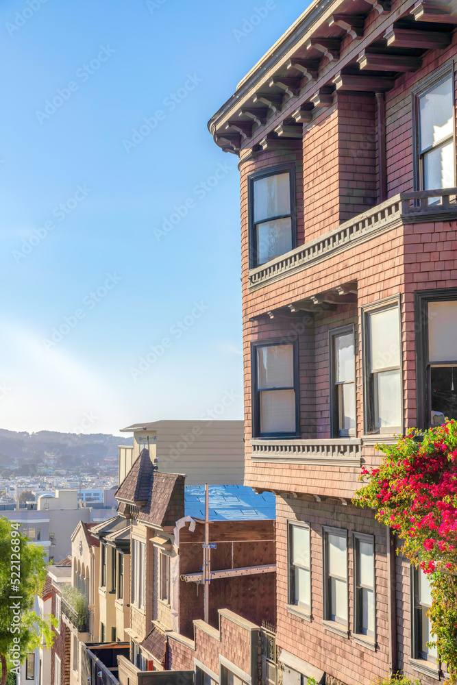 Uphill row of houses with a view of the neighborhood below at San Francisco, CA