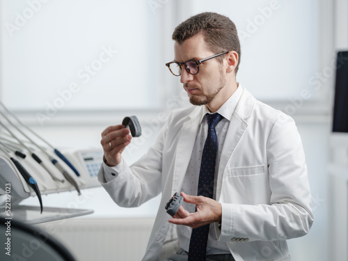 Dentist looking at photopolymer jaw printed on a 3d printer. photo