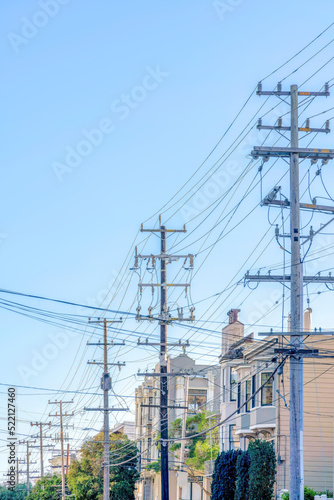 Row of electrical posts with tangled wires in the urban area of San Francisco, California
