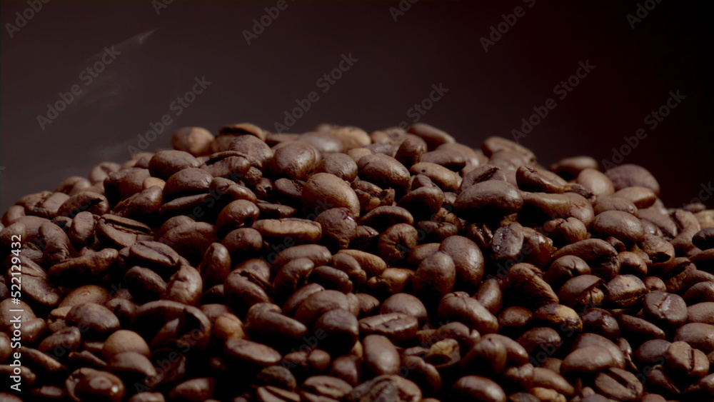 Fototapeta premium Closeup heap roasted coffee grains on dark backdrop. Coffee beans background.