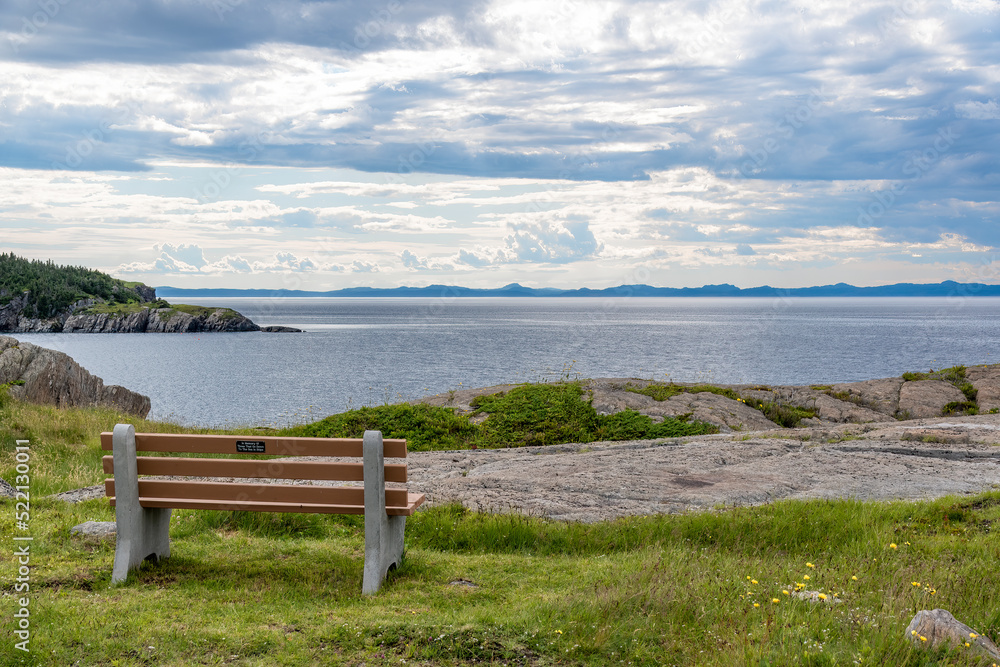 An empty bench looks out over the Atlantic Ocean at the Heart's Content lighthouse in Newfoundland.