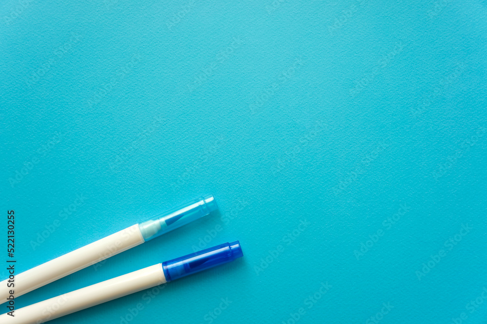 The creative concept of creativity is empty. Two felt-tip pens blue and blue lie off the edge of the blue kraft background. Back to school. Medical Notes. In aquamirin tones. Recipe The creative concept of creativity is empty. Two felt-tip pens blue and blue lie off the edge of the blue kraft background. Back to school. Medical Notes. In aquamirin tones. Recipe