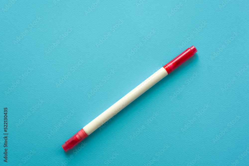The creative concept of creativity is empty. A single red marker for marking lie off the edge of the blue kraft background. Back to school. Medical Notes. In aquamirin tones. Recipe The creative concept of creativity is empty. A single red marker for marking lie off the edge of the blue kraft background. Back to school. Medical Notes. In aquamirin tones. Recipe