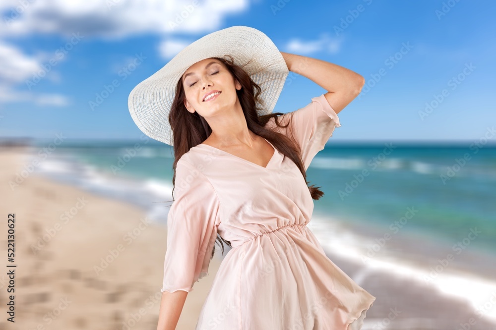 Smiling woman relaxing on beach background. Happy woman standing on the sun beach Smiling woman relaxing on beach background. Happy woman standing on the sun beach