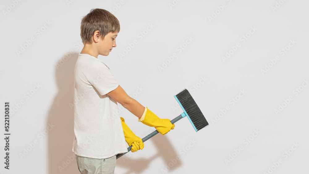 A teenager in rubber gloves, saddled a mop and will say it like a horse. Equestrian dream concept. A teenager in rubber gloves, saddled a mop and will say it like a horse. Equestrian dream concept.