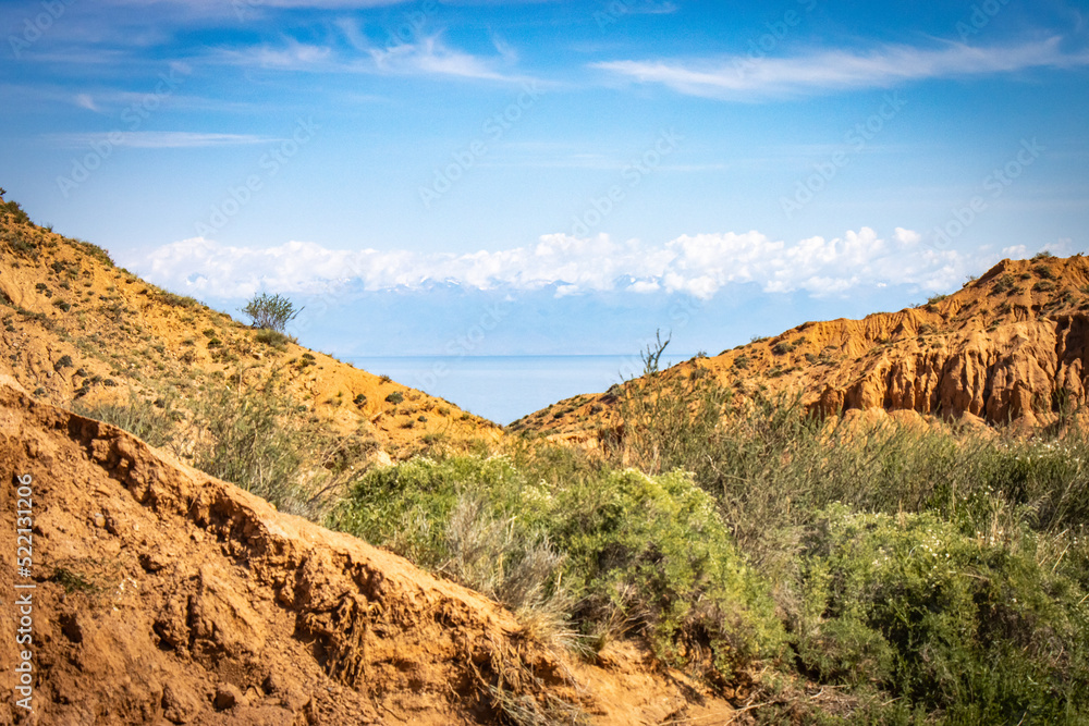 Obraz premium Fairytale canyon, Kyrgyzstan, Silk Road, Central Asia, red rocks, colourful, Yssykkul lake in background