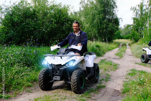 Happy man on the ATV Quad Bike in the forest