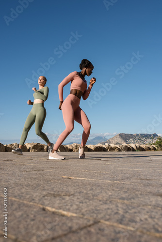 Diverse female athlete doing zig zag run photo