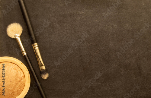 Set of professional cosmetic: make-up brushes, shadows, lipstick, nail polishes on black background.