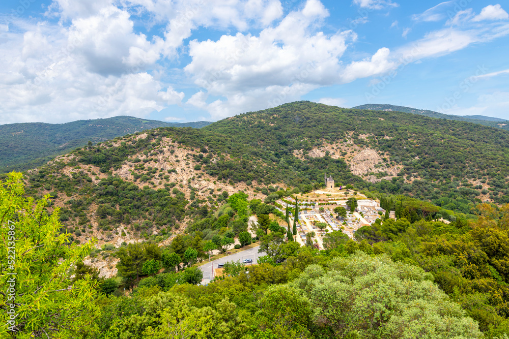 View from the walls of the hilltop medieval castle with the Moulin Saint Roch Gardiole windmill and Grimaud cemetery in view in the hills of Provence Cote d'Azur France.