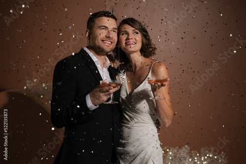 Happy Newlyweds With Confetti Rain  photo