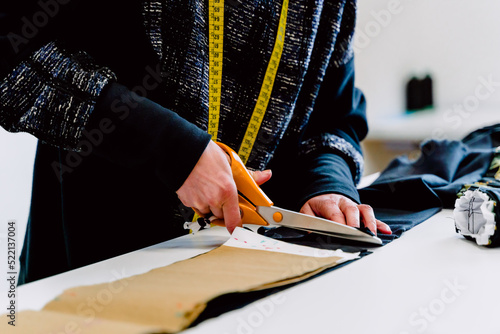 Obraz na płótnie Dressmaker with scissors cutting cloth. w salonie